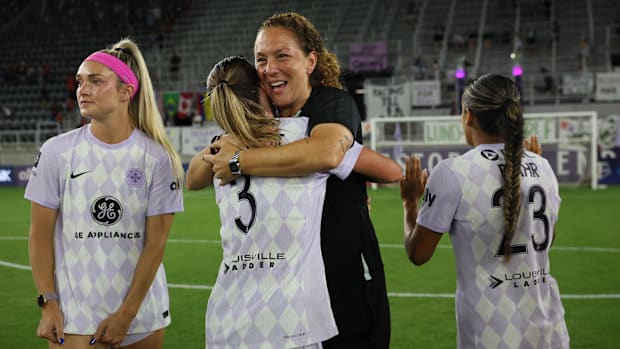 El entrenador asistente Louisville Carmelina Moscato (tercero a la izquierda) cubre a los jugadores en el estadio familiar Lynn.