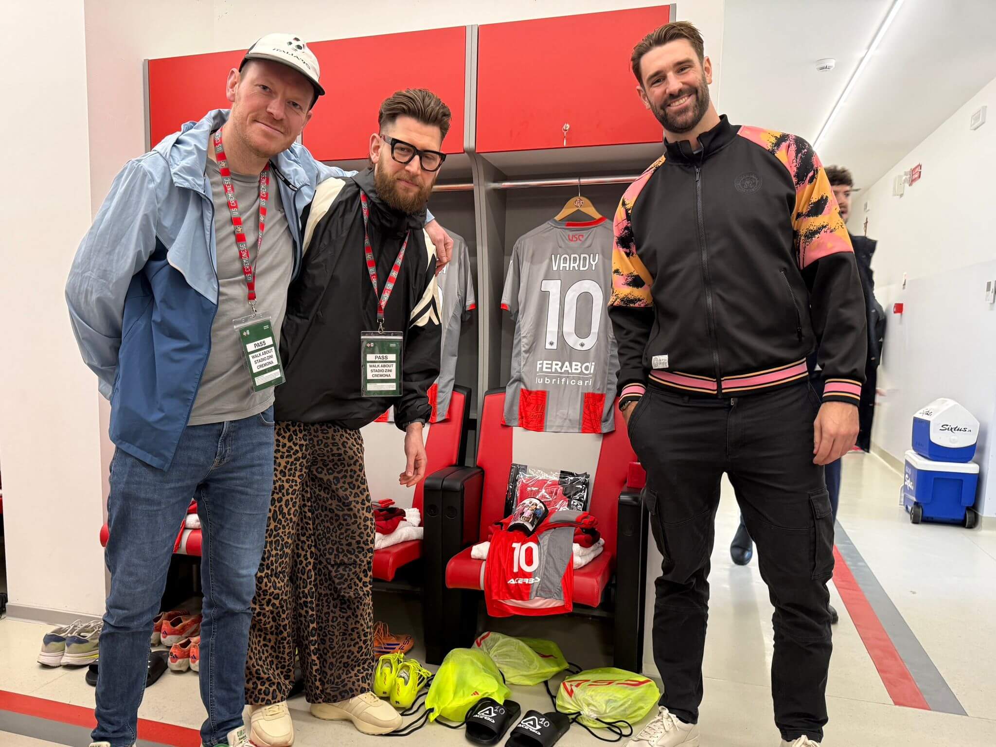 Ric Flair, Jordan Halford y Jake Watson posan con la equipación de Jamie Vardy antes del partido de Génova
