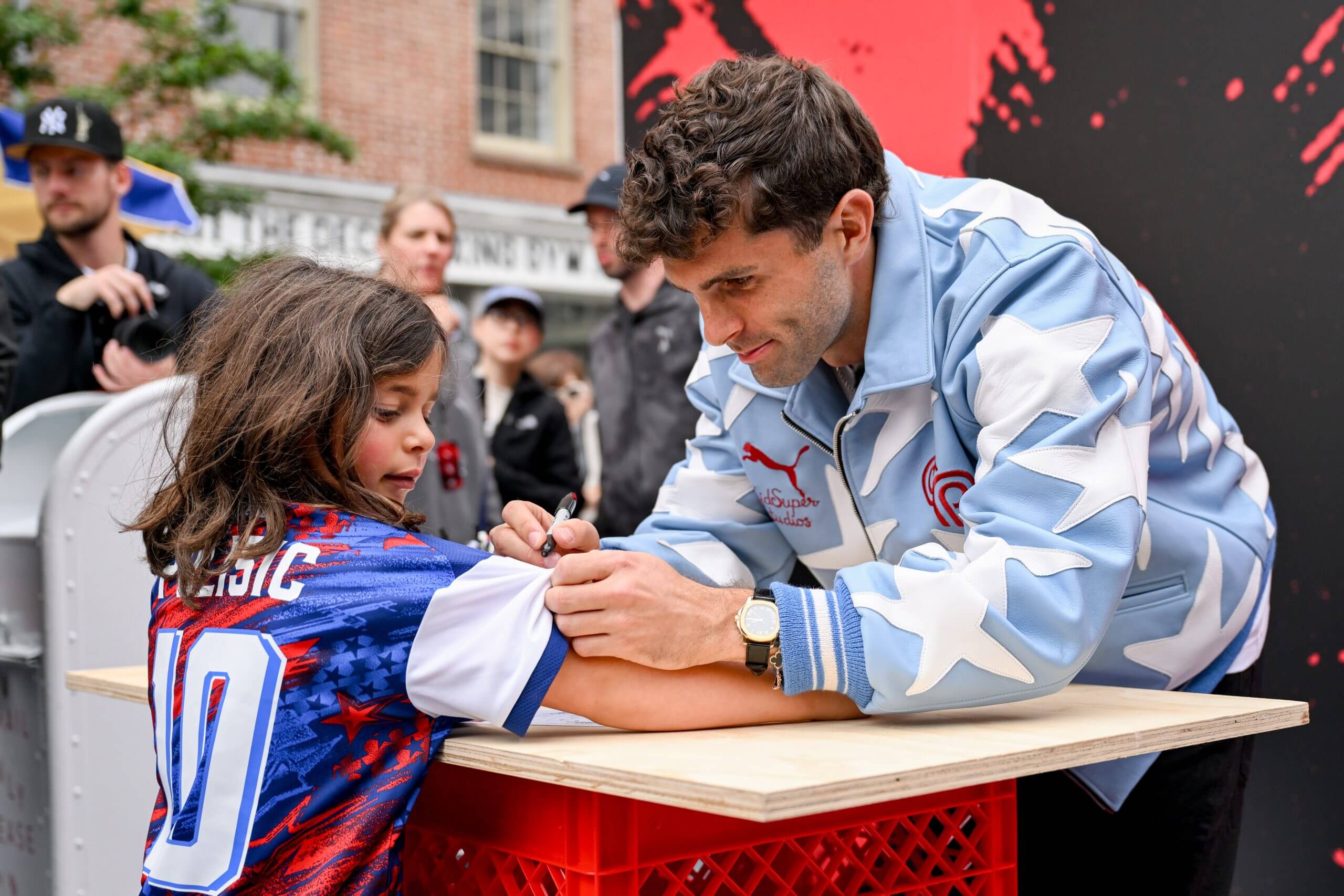 Christian Pulisic firma un autógrafo para un joven aficionado