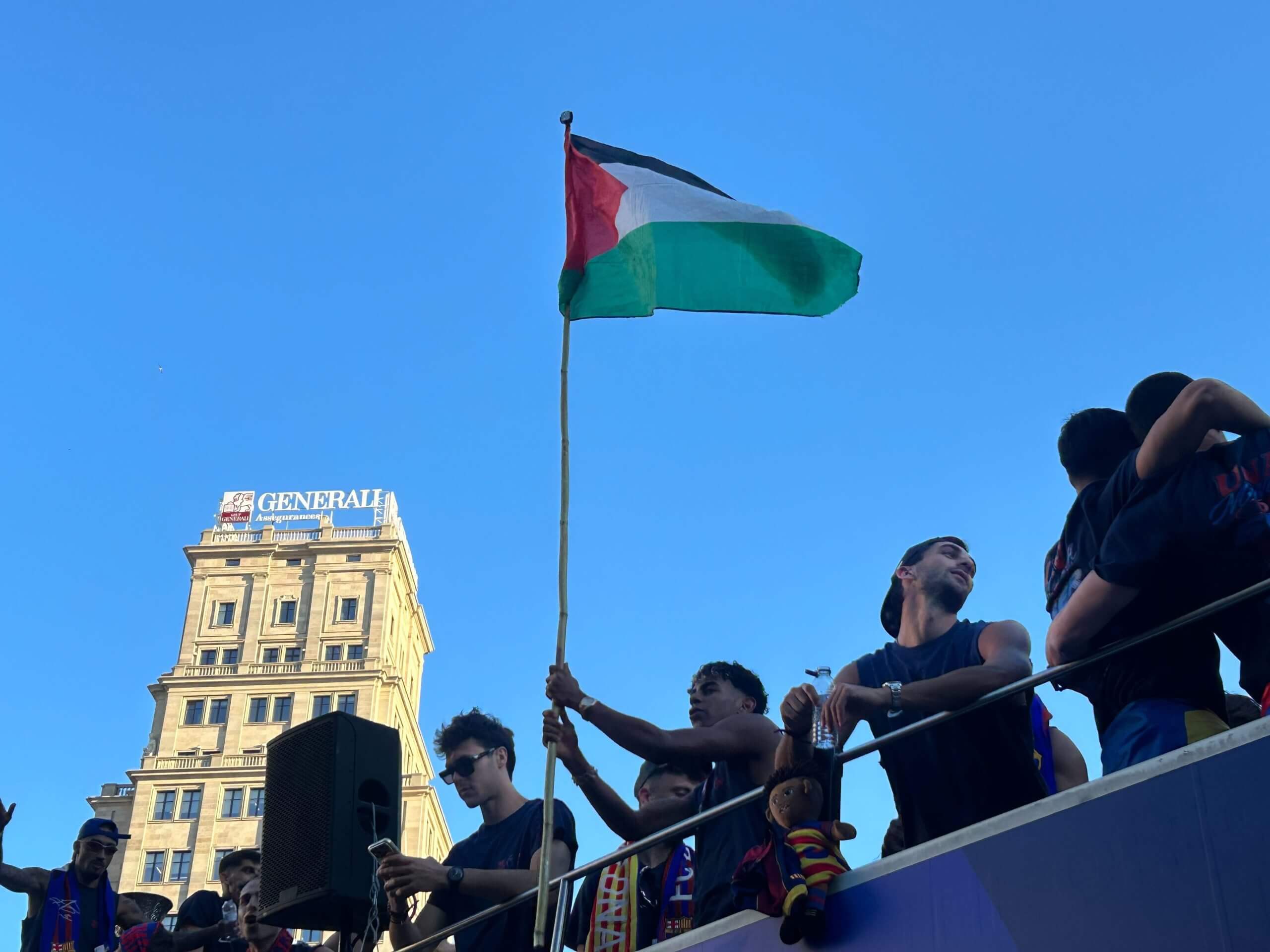 Lamin Yamal ondea una bandera palestina durante un recorrido en autobús por Barcelona el lunes
