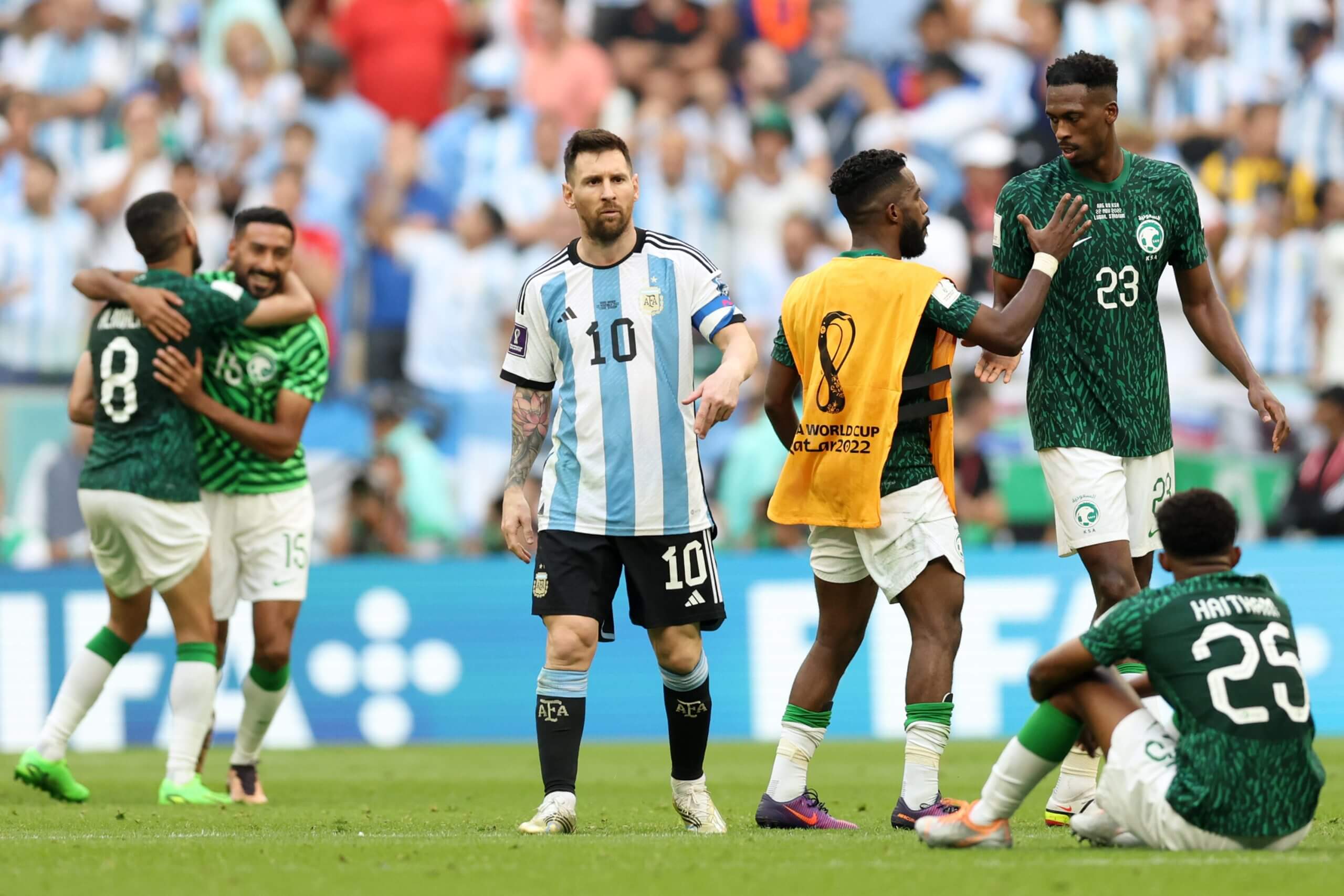 Los jugadores de Arabia Saudita celebran con un sorprendido Lionel Messi después de su victoria en la fase de grupos sobre Argentina en 2022.
