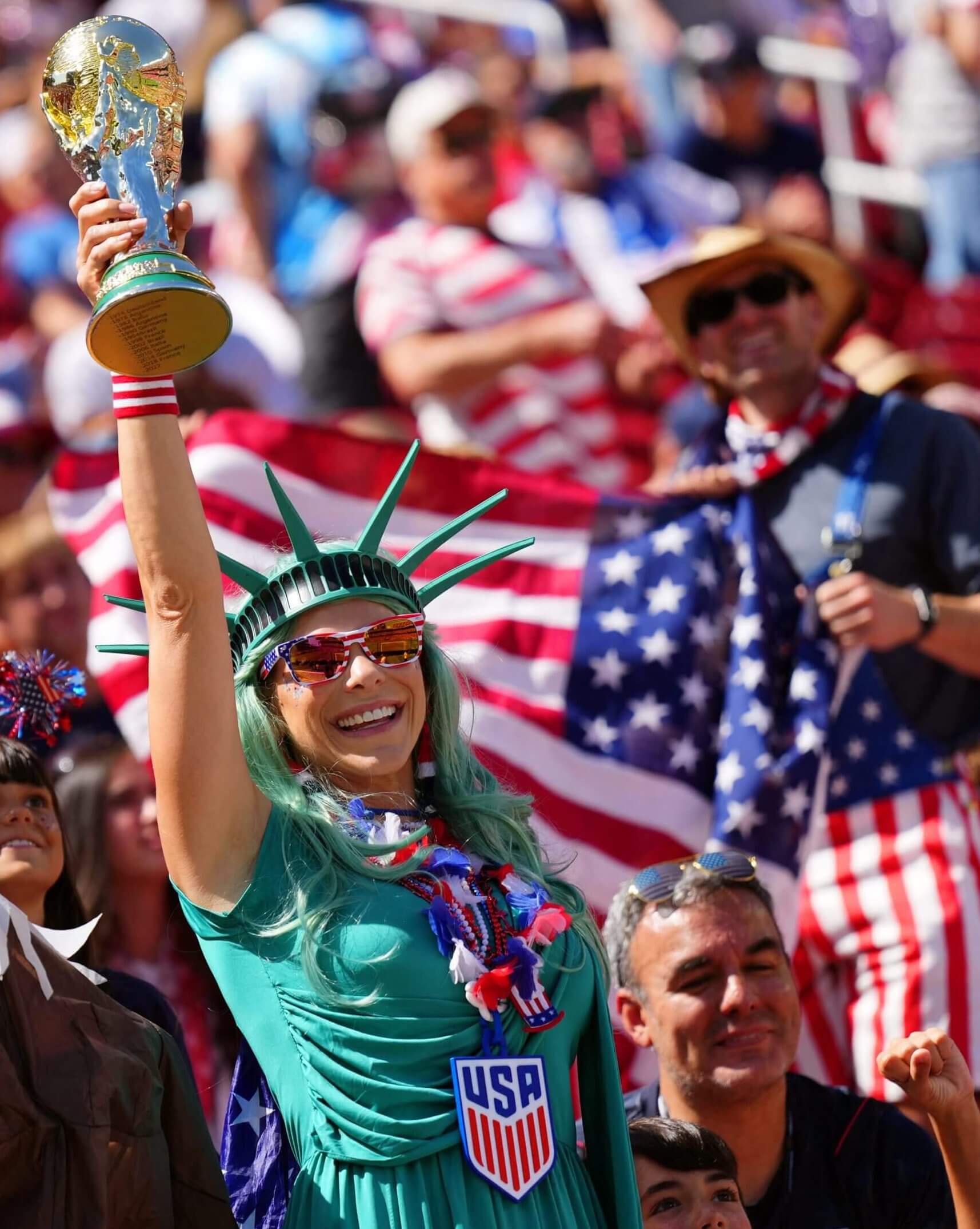 A United States fan wearing a Statue of Liberty costume displays a replica World Cup trophy (Darren Yamashita / Imagn Images)