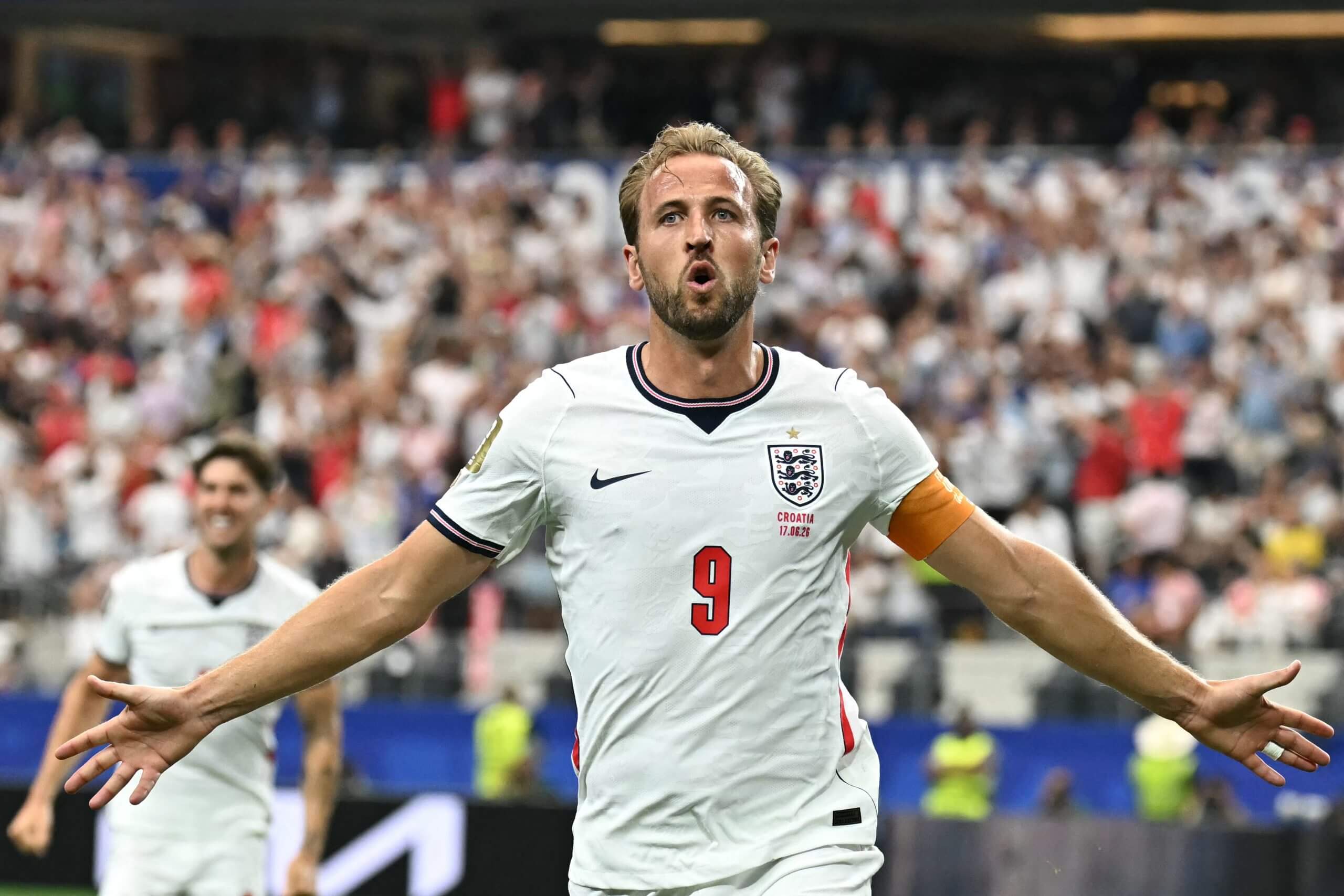 Kane celebra con los brazos extendidos mientras John Stones celebra de fondo