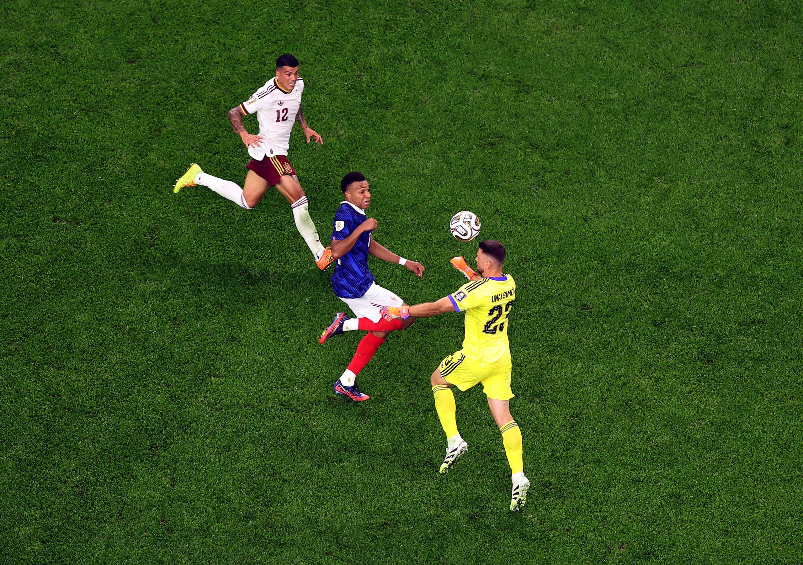 Unai Simon runs out of his box to head clear as Kylian Mbappe threatens for France