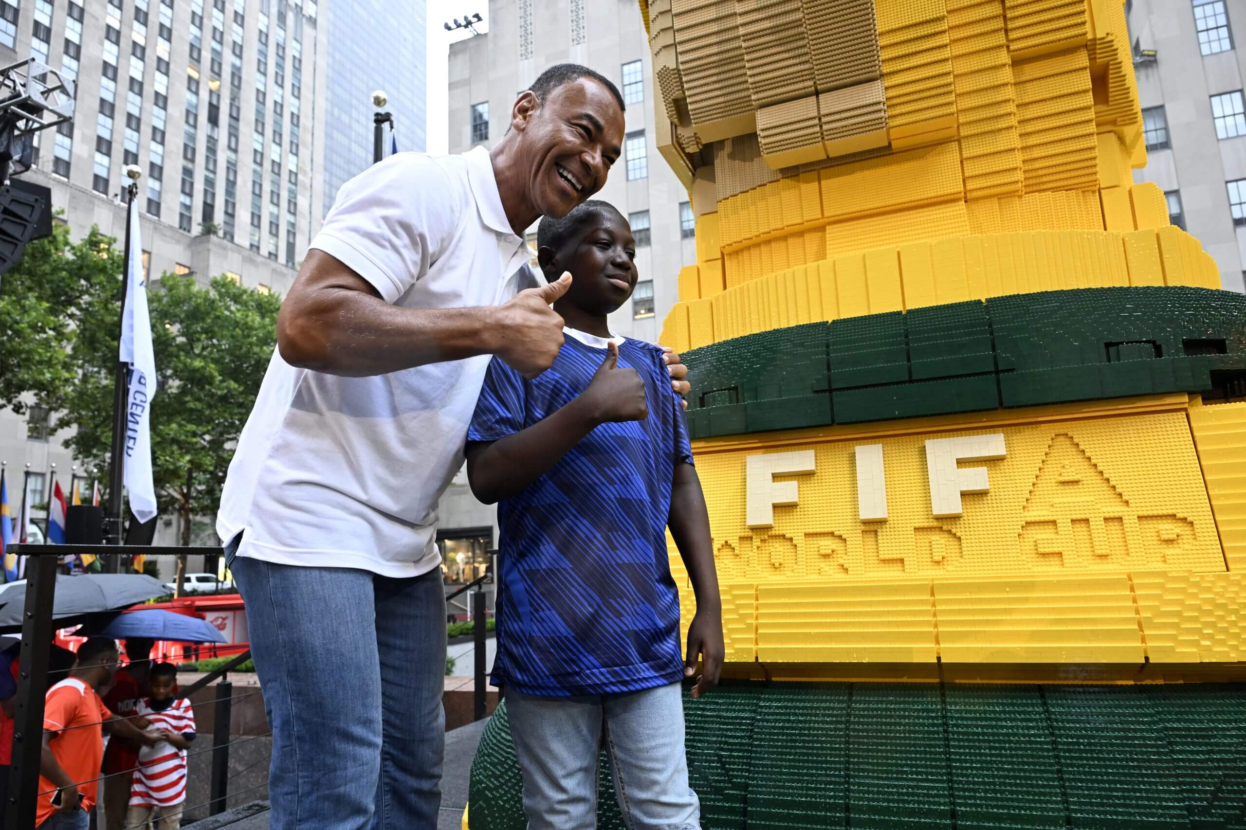 Cafú posa con un niño junto a una escultura de Lego del Mundial. 