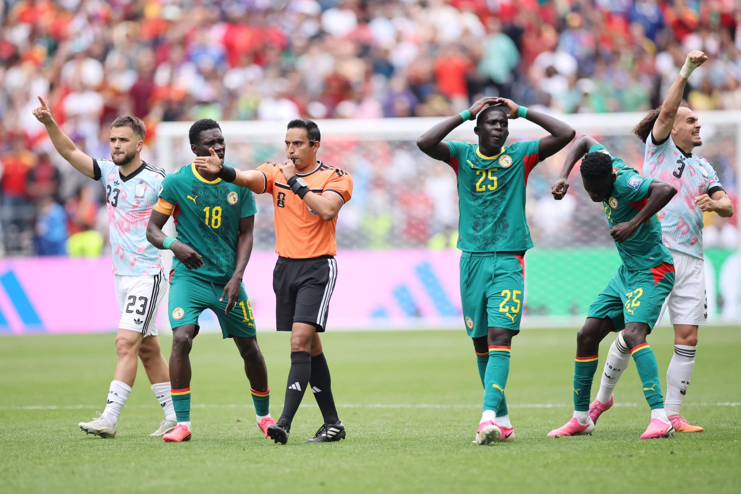 Senegal's players protest the award of Belgium's late penalty 