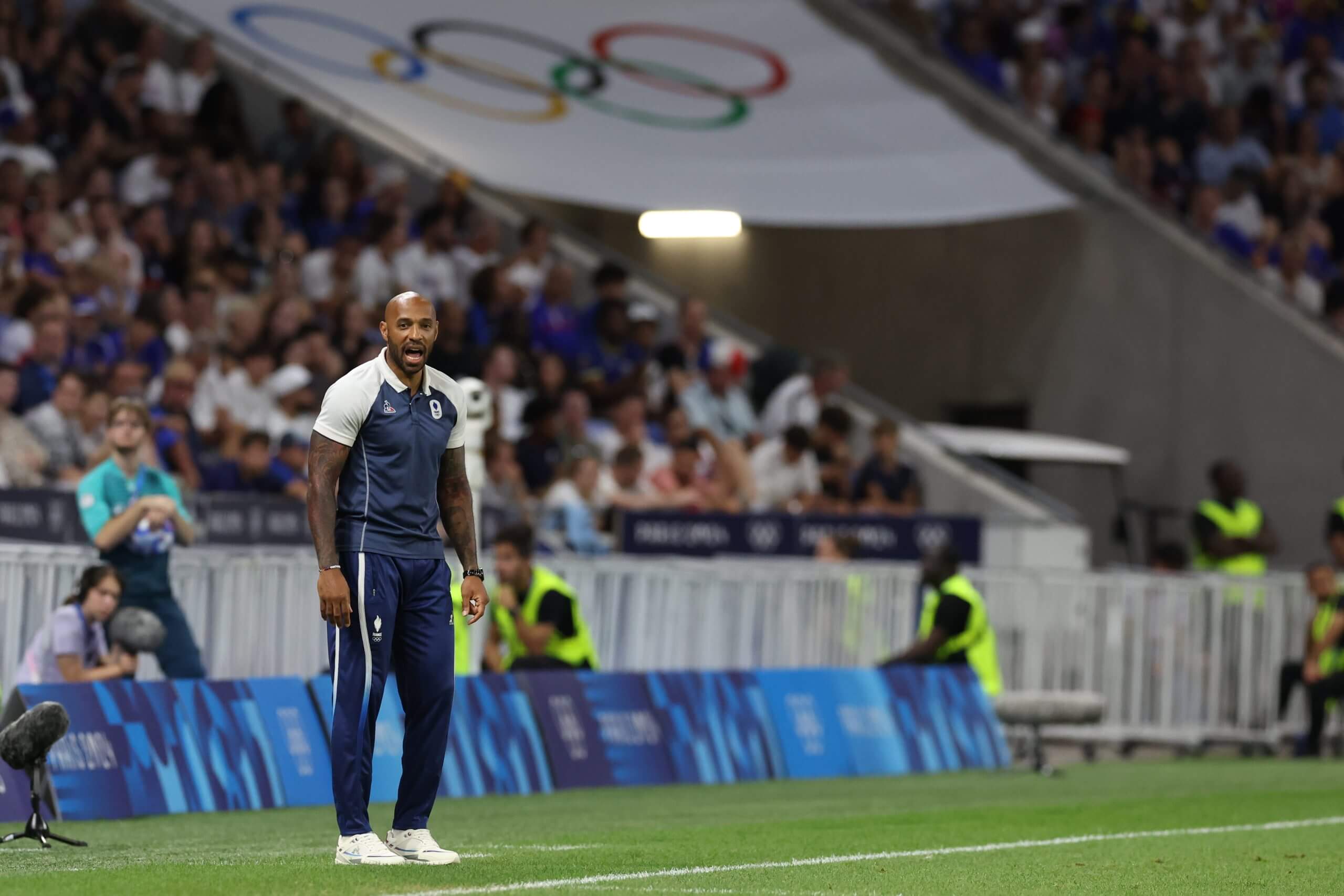 Un entrenador de fútbol en la línea de banda durante un partido olímpico
