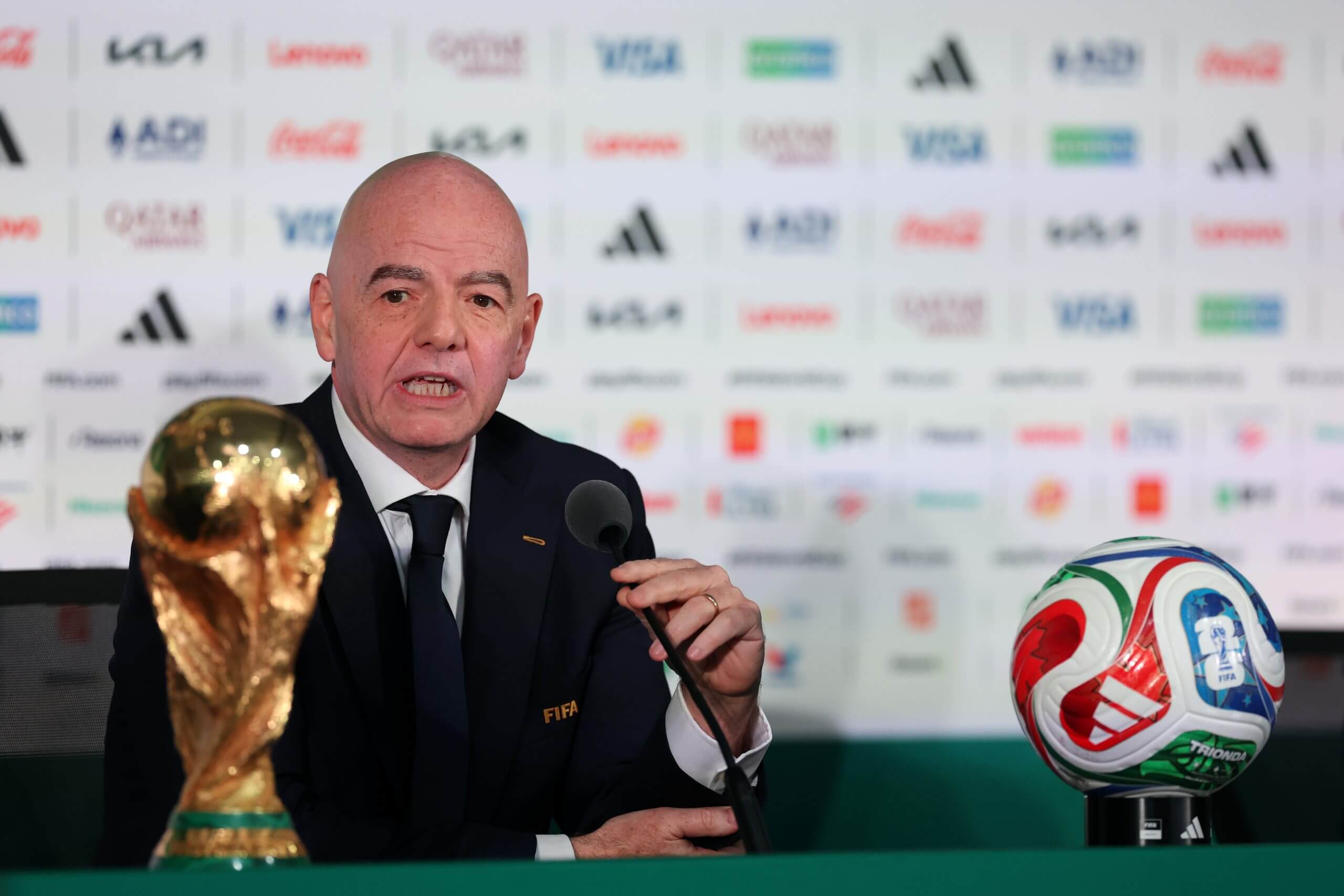 Infantino en conferencia de prensa con el trofeo y el balón del Mundial